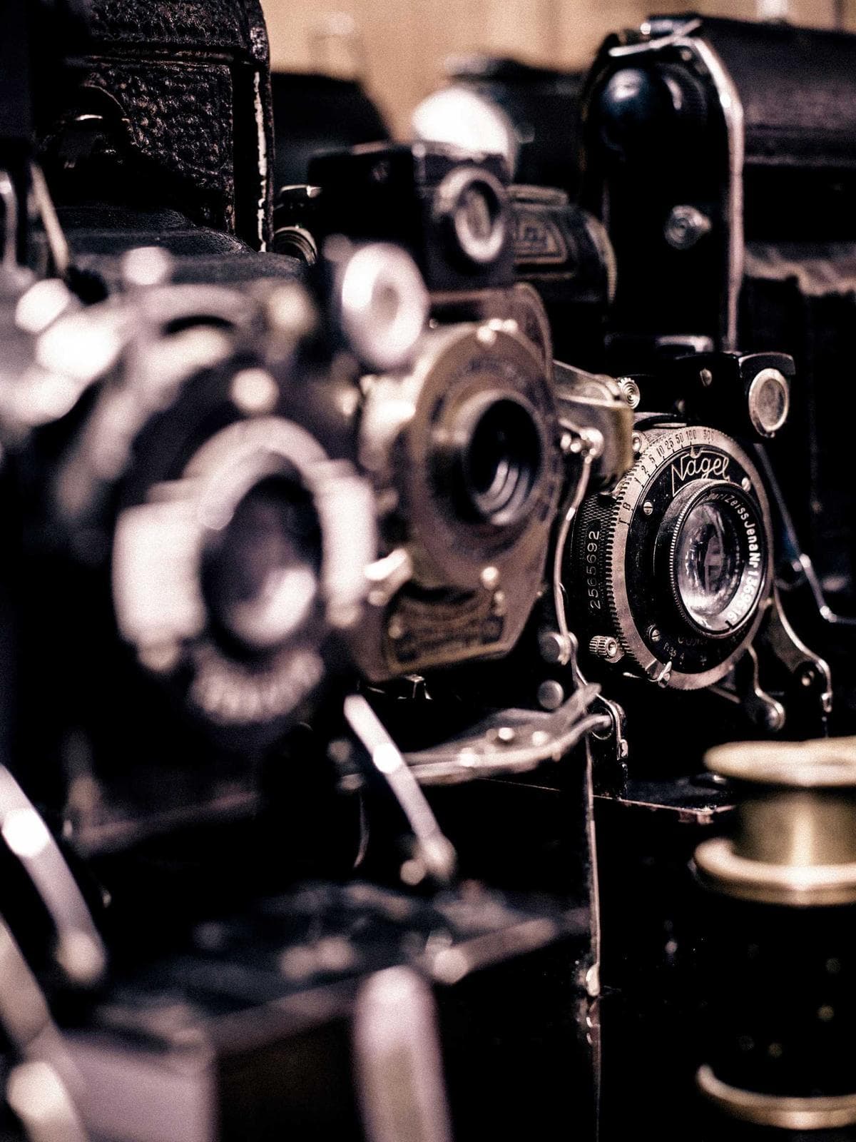 Camera bodies and lenses raking light in a dark studio