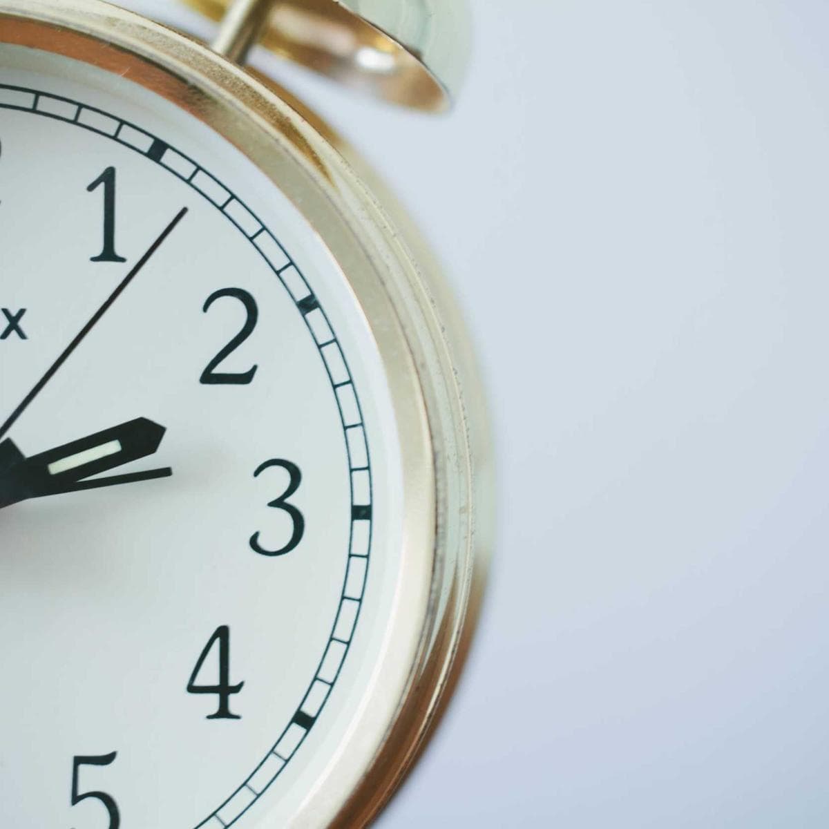 Macro of an analogue clock face behind glass